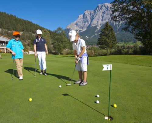 a group of people playing golf on a golf course at Haus Montana in Lermoos