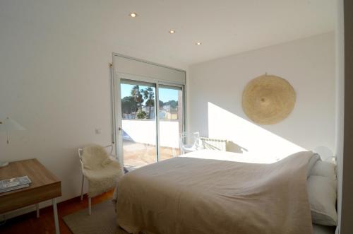 a bedroom with a bed and a desk and a window at Ponent in L'Escala