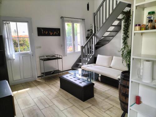 salon z białą kanapą i schodami w obiekcie Maison dans une résidence de vacances w mieście Gallargues-Le-Montueux