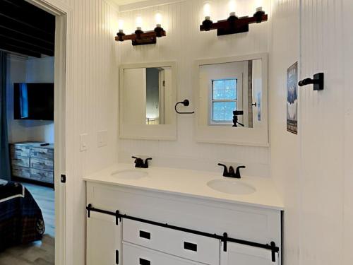 La salle de bains est pourvue de 2 lavabos et de 2 miroirs. dans l'établissement Jireh Mount Cabin, à Cosby
