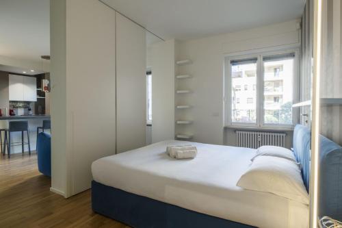 a bedroom with a large bed and a kitchen at Easylife - Confortevole appartamento in Bocconi in Milan