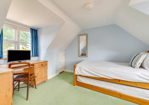 a bedroom with a bed and a desk with a computer at The Spinney in Reydon