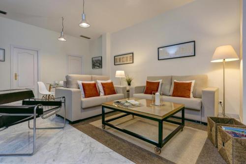 a living room with a couch and a table at Genteel Home Tomás de Ibarra in Seville