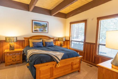 1 dormitorio con 1 cama de madera y 2 ventanas en Fantastic Home In Woods With Hot Tub! en South Lake Tahoe