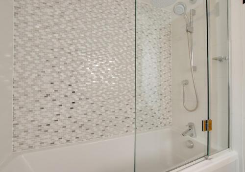 a shower with a glass door in a bathroom at Wren Cottage in Woodbridge