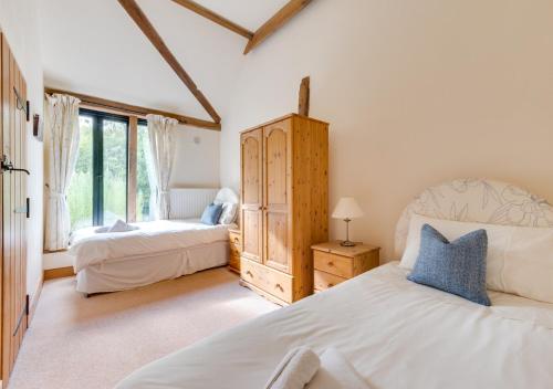 a bedroom with two beds and a large window at Willow Cottage at Wattisham Hall in Wattisham