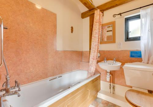 La salle de bains est pourvue d'une baignoire, d'un lavabo et de toilettes. dans l'établissement Willow Cottage at Wattisham Hall, à Wattisham