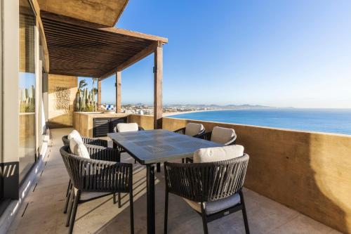 a patio with a table and chairs and the ocean at Private Hot Tub - Ocean View - GYM - Free Parking in San José del Cabo