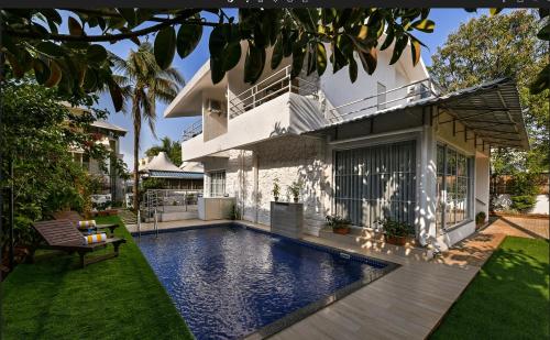 ein Haus mit einem Swimmingpool vor einem Haus in der Unterkunft Meritas Countryside Resort Lonavala in Lonavla