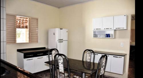 una cucina con un tavolo e un frigorifero bianco di Casa 29 casa inteira a Pirenópolis