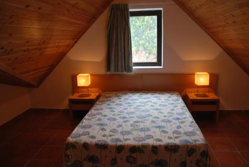 a bedroom with a bed and two lamps on tables at Apartamentos Turisticos Nossa Senhora Da Estrela in Rosário-Lagoa