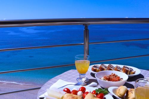 a table with plates of food and a glass of orange juice at Anel Rooms in Himare