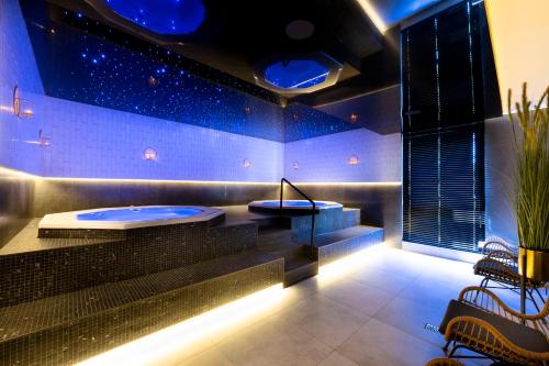 uma sala de spa com jacuzzi no meio em Holiday Golden Resort & Spa em Łazy