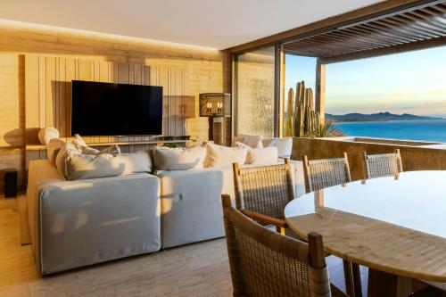 a living room with a couch and a television at Private Hot Tub - Ocean View - GYM - Free Parking in San José del Cabo