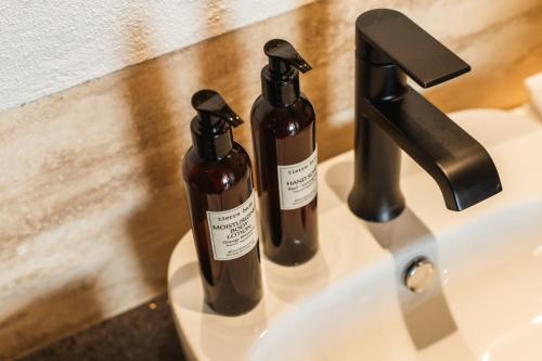 two bottles of soap sitting on a bathroom sink at Private Hot Tub - Ocean View - GYM - Free Parking in San José del Cabo
