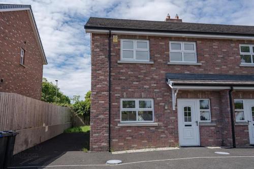 a red brick house with a white door at Cashel on the Coast, 3 bedroom holiday home, Ballycastle in Ballycastle