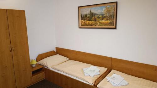 2 camas en una habitación con una foto en la pared en Motel Velký Rybník, en Pelhřimov