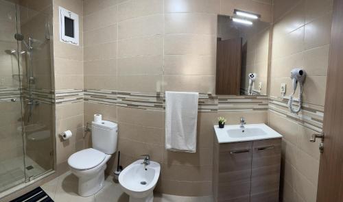 La salle de bains est pourvue de toilettes, d'un lavabo et d'une douche. dans l'établissement Appartement moderne avec piscine à Marrakech, à Marrakech