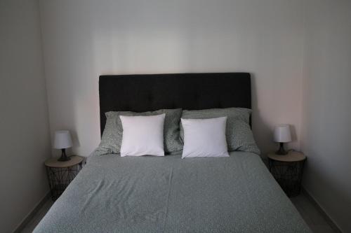 um quarto com uma cama com 2 almofadas e 2 candeeiros em Apartament Niechorze em Niechorze