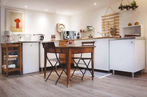 a kitchen with a wooden table and a counter at Duplex dans village avec jardin in Claix