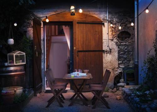 un tavolo e sedie di fronte a una porta di Duplex dans village avec jardin a Claix