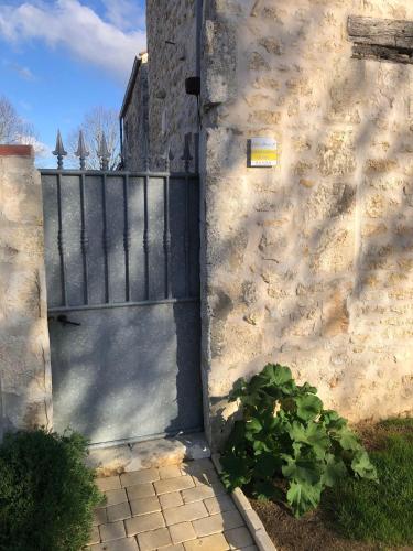 une porte menant à une maison avec une clôture et une plante dans l'établissement Le Chai & L'écurie - Gîtes de charme entre plage et cœur de village, à Dolus-d'Oléron
