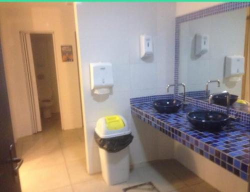 a bathroom with two sinks and a blue tile counter at Lakehouse 24hs Hostel Lagoa Conceicāo in Florianópolis