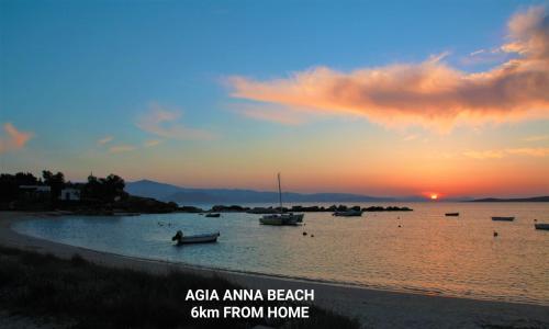 a beach with boats in the water at sunset at Passa Corda Suites with amazing view in Galanado