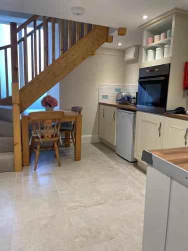 a kitchen with a table and a dining room at The Groom's Cottage in Towcester