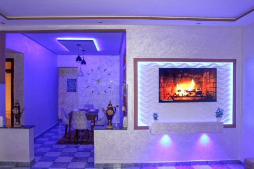uma sala de estar com lareira e iluminação roxa em IDGA appartement with panoramic view em Chefchaouen