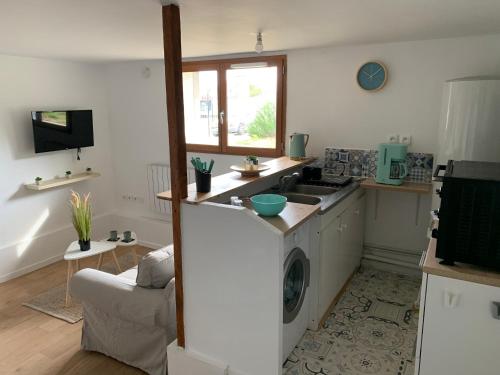 une cuisine avec un évier et une machine à laver dans l'établissement Logement à 20 min de Paris avec parking gratuit, à Eaubonne