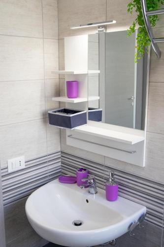 a bathroom with a white sink and a mirror at Appartamento Profumo di Mare in Marina di Ragusa