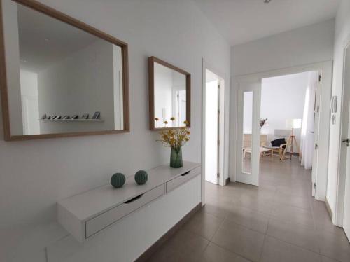 Sala de estar blanca con espejo grande y lavamanos en Apartamento Exclusivo San Marcos, en Manzanares