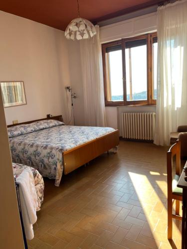 een slaapkamer met 2 bedden en een groot raam bij Villa Fè -Choose Panoramic View, Jacuzzi, Private Parking in Montepulciano