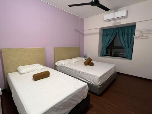 a room with two beds and a window with blue curtains at BayView Villas Condo - Premium Unit in Port Dickson