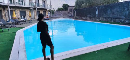 a woman standing next to a swimming pool at My Holiday - Alessandra Residence - Domaso in Domaso