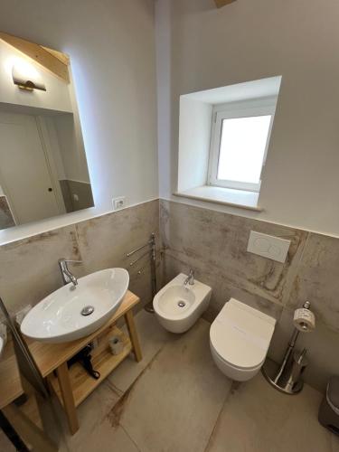 ein Badezimmer mit einem Waschbecken, einem WC und einem Spiegel in der Unterkunft De LoCa Rooms in Tropea