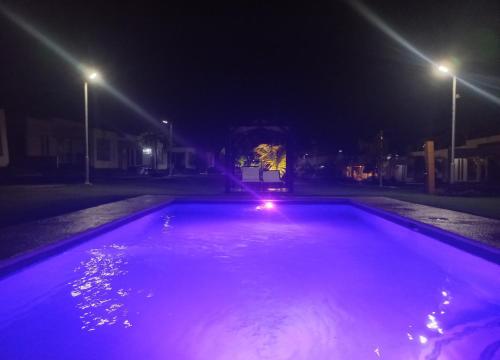 an empty swimming pool at night with purple lights at ADVENTURE House in Nancito