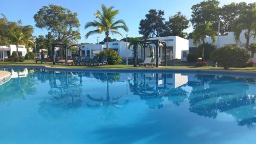 a swimming pool with blue water and palm trees at ADVENTURE House in Nancito