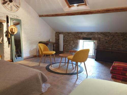 een kamer met 2 stoelen en een bed en een tafel bij Au Ruisseau de Rose in Saint-Jean-du-Gard
