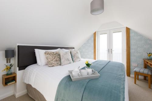 ein Schlafzimmer mit einem großen Bett und einem Tablett darauf in der Unterkunft The Hayloft in Chichester