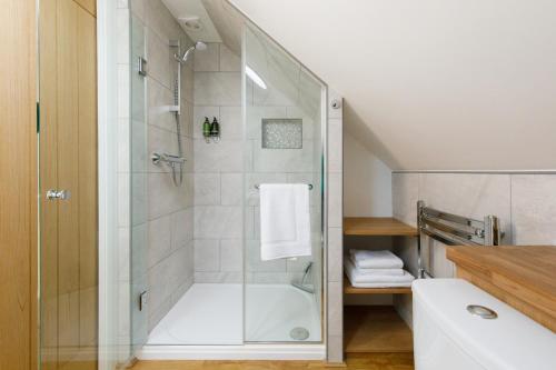 a bathroom with a shower with a glass door at The Hayloft in Chichester