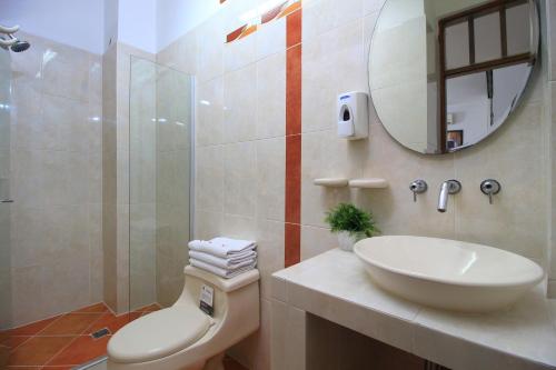 uma casa de banho com um lavatório, um WC e um espelho. em Hotel Emberá em Apartadó