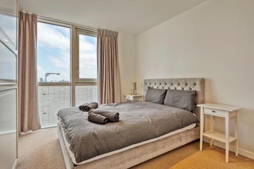 una camera da letto con un letto e una grande finestra di Delightful Apartment Wandsworth a Londra