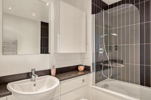 bagno bianco con lavandino e doccia di Delightful Apartment Wandsworth a Londra