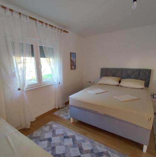 a white bedroom with a bed and a window at Herzegovinian Hobbiton in Stolac