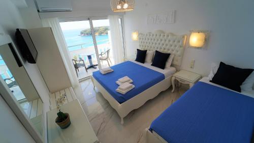 a bedroom with a blue bed and a view of the ocean at Valtos View in Parga