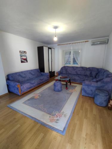 a living room with blue couches and a rug at Herzegovinian Hobbiton in Stolac