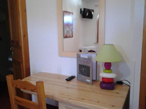 a wooden table with a lamp and a mirror at Hotel Villa Stella in Cascia