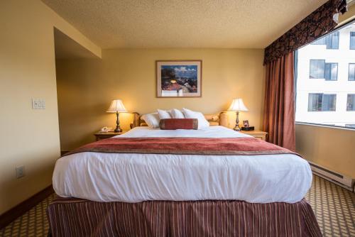 a large bed in a hotel room with a window at The Grand Lodge Hotel and Suites in Mount Crested Butte